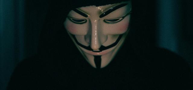 a person wearing a mask using a cell phone by Erik Mclean courtesy of Unsplash.